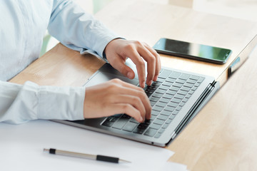 business woman typing on laptop keyboard working on the desk in office