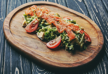 Red fish with sesame on vegetables On the black table