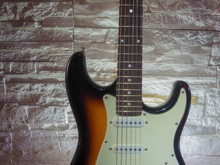 Obraz premium Electric guitar of dark color with light inserts with metal strings