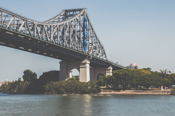 City bridge above shore with green trees