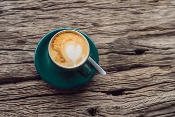 A cup of coffee on the background of an old wooden table A heart for coffee. St. Valentine's Day concept