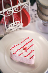 Strawberry cake in the form of a heart on a white plate