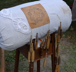 Klöppelkissen mit Klöppeln auf einem Holzgestell auf einem Flohmarkt