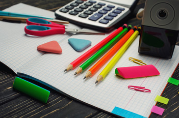On the notebook there are pens, pencils, calculators