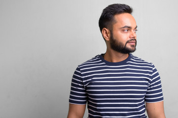 Young bearded Indian man against white background