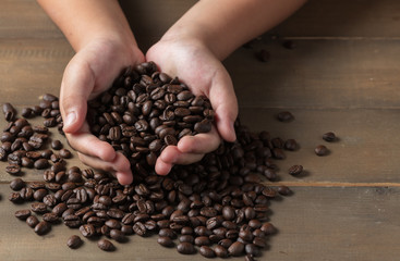 Fresh coffee beans in hands child, drink concept