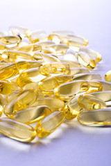 Capsules of fish fat oil on a white background with space for text