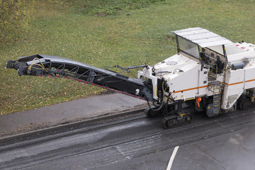 Road milling machine in anticipation of a dump truck. Road repair process