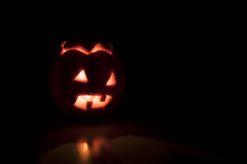 Scary orange halloween pumpkin in the darkness