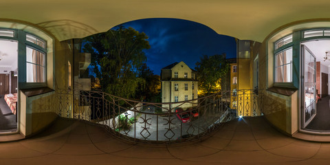 Full seamless 360 degrees angle view night panorama from balcony of small hostel overlooking the courtyard and bedroom in old town in equirectangular projection.