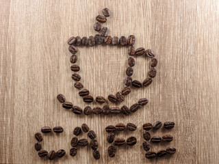 The coffee beans are arranged in a pattern of a cup of hot coffee, with the word 