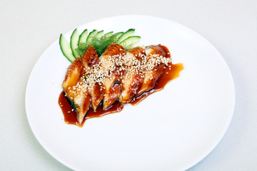 Smoked eel with gravy and cucumber. Sashimi Unagi. Japanese food on a beautiful dish. Dietary food. An exquisite Japanese dish.