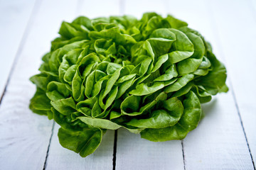 fresh green and healthy lettuce on an old white wooden table