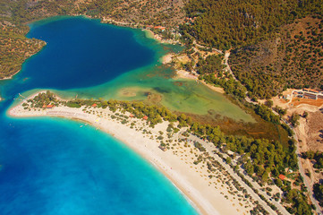 Fototapeta na wymiar Aerial view of Blue Lagoon in Oludeniz, Turkey. Landscape with mountains, green forest, azure water, sandy beach and blue sky in bright sunny day.