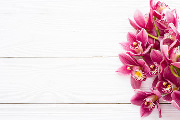 Spa and wellness setting with orchid flower, oil on wooden white boards background closeup top view