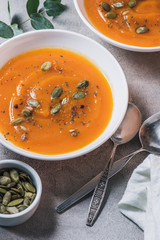 close up view of plates with pumpkin cream soup with seeds on table