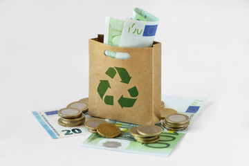 Paper shopping bag with green recycle symbol on money - Ecology concept