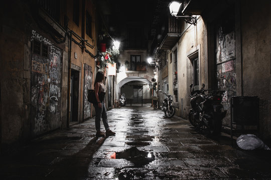 Anonymous woman on dark street at night