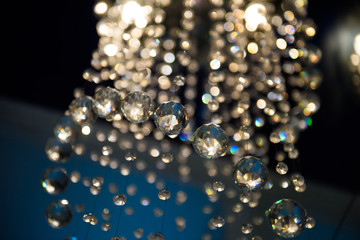 Chandelier hanging long with crystal balls. Light in the room in an elegant design. 