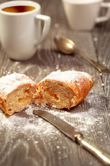 Croissant and coffee on wood table background