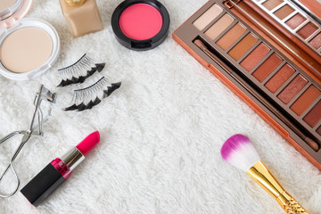 Flat lay of beauty cosmetic products and Various Make up accessories on the white fur background with copy space for your text. Concept of Beauty Knolling.