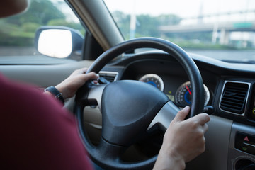 Commuting woman driving car on city road