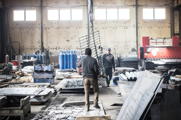 Workers in boots walk inside the industrial factory