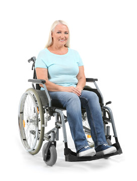 Mature woman sitting in wheelchair on white background