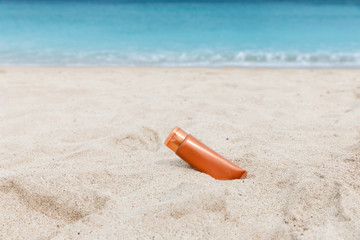 Sunscreen sunblock spf cream on the sea beach sand summer tropical holiday concept