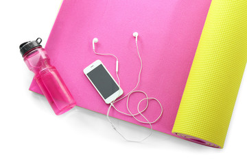 Yoga mat with bottle of water and phone on white background