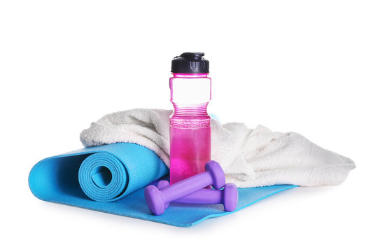 Yoga mat with bottle of water, dumbbells and towel on white background  Stock Photo