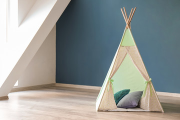 Cozy play tent for kids near color wall