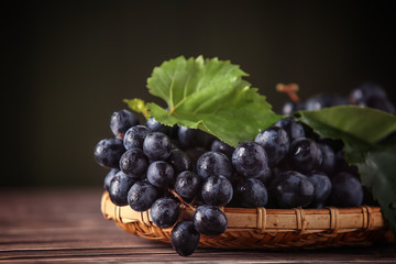 Tray with ripe sweet grapes on wooden table