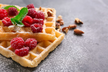 Delicious waffles with raspberries on table, closeup