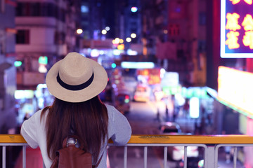 Woman is looking at Mong Kok Night Market in Hong Kong.