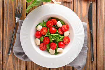 Fresh tomatoes with basil and mozzarella on plate