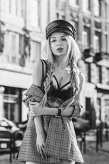 Outdoor monochrome fashion portrait of young beautiful sensual woman wearing stylish leather cap,...
