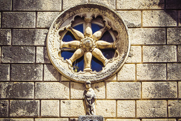 Stone facade of old catholic church with round window, Dubrovnik, Croatia