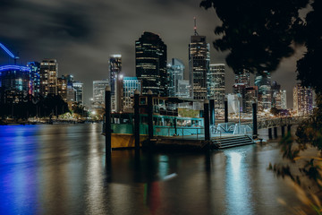 Pier on city river at night