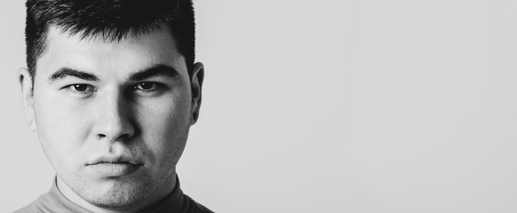 Closeup portrait of serious determined young man. Isolated on grey background with copy space.