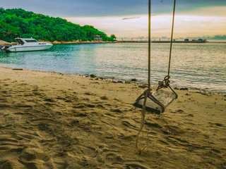 Wooden swing on the Beach beside the ocean in vacation time