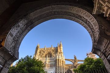 facade of the sevilla cathedral framed by the arabic arch of the door of forgiveness in Seville,...