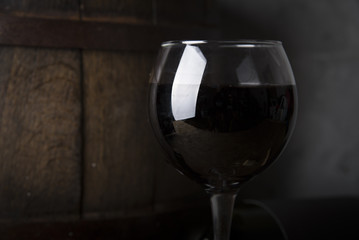 Excellent red wine bottles, wineglass, barrel and corkscrew on a rustic wooden table: traditional...