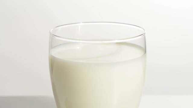 Vaso de leche en la mesa blanca, detalle