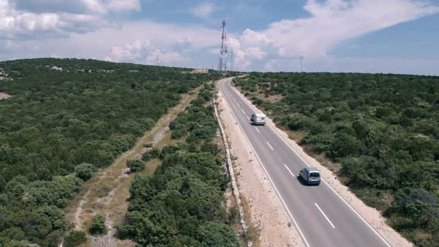 Aerial - Cars and a camper driving on island road on Cres