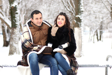 A young couple walk in a winter park