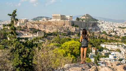 Teen standing on hill in facing the Acropolis - obrazy, fototapety, plakaty