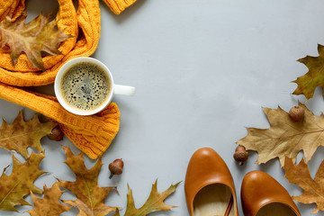 Feminine autumn accessories. Scarf and shoes, cup of coffee, oak leaves and acorns on gray wooden...