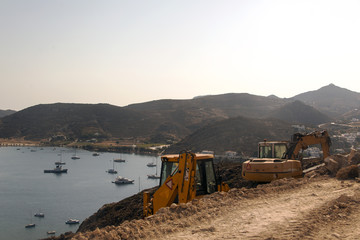 Fototapeta na wymiar Excavators and construction site and the beach in Patmos, Greece in summer time
