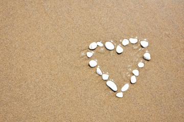 Fototapeta na wymiar White heart on sand